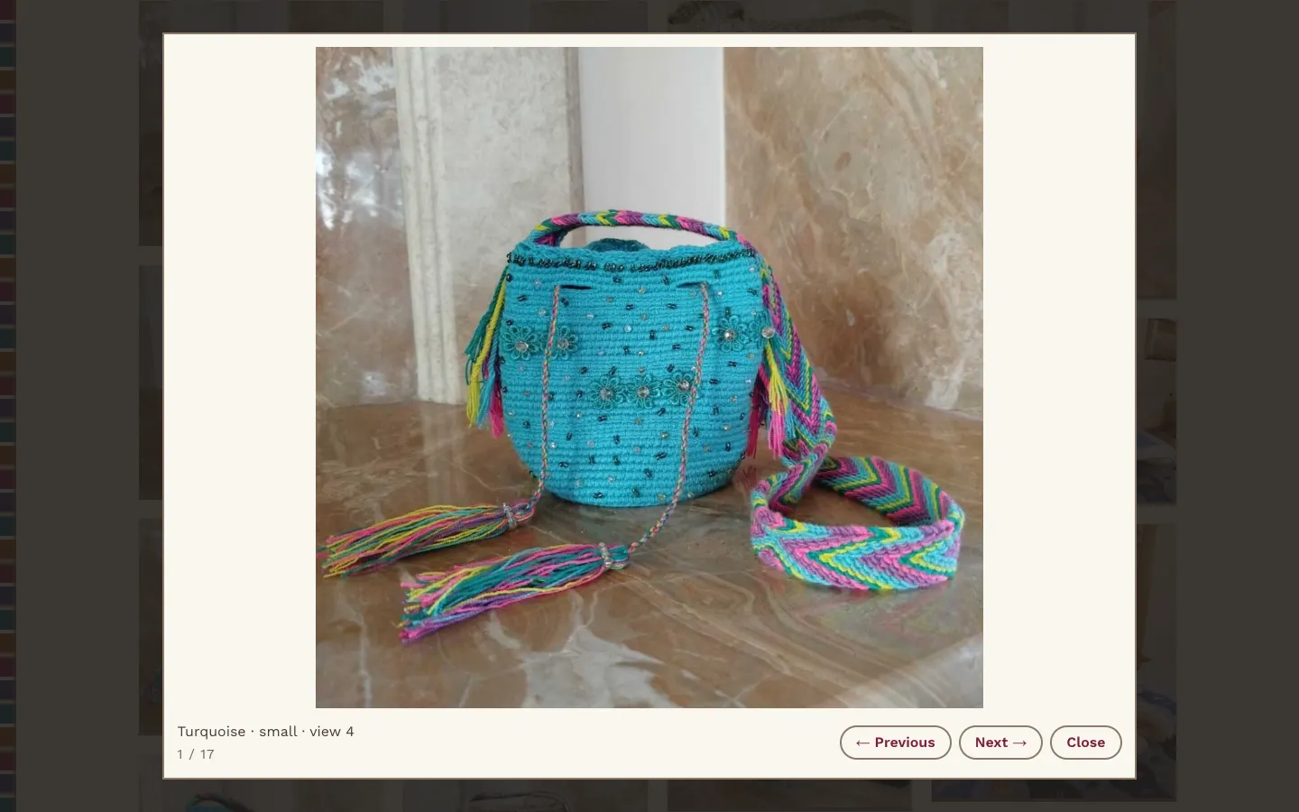 An enlarged view of a turquoise Wayuu bag with braided multicolor straps, labeled 'Turquoise, small, view 4', with Previous, Next and Close buttons